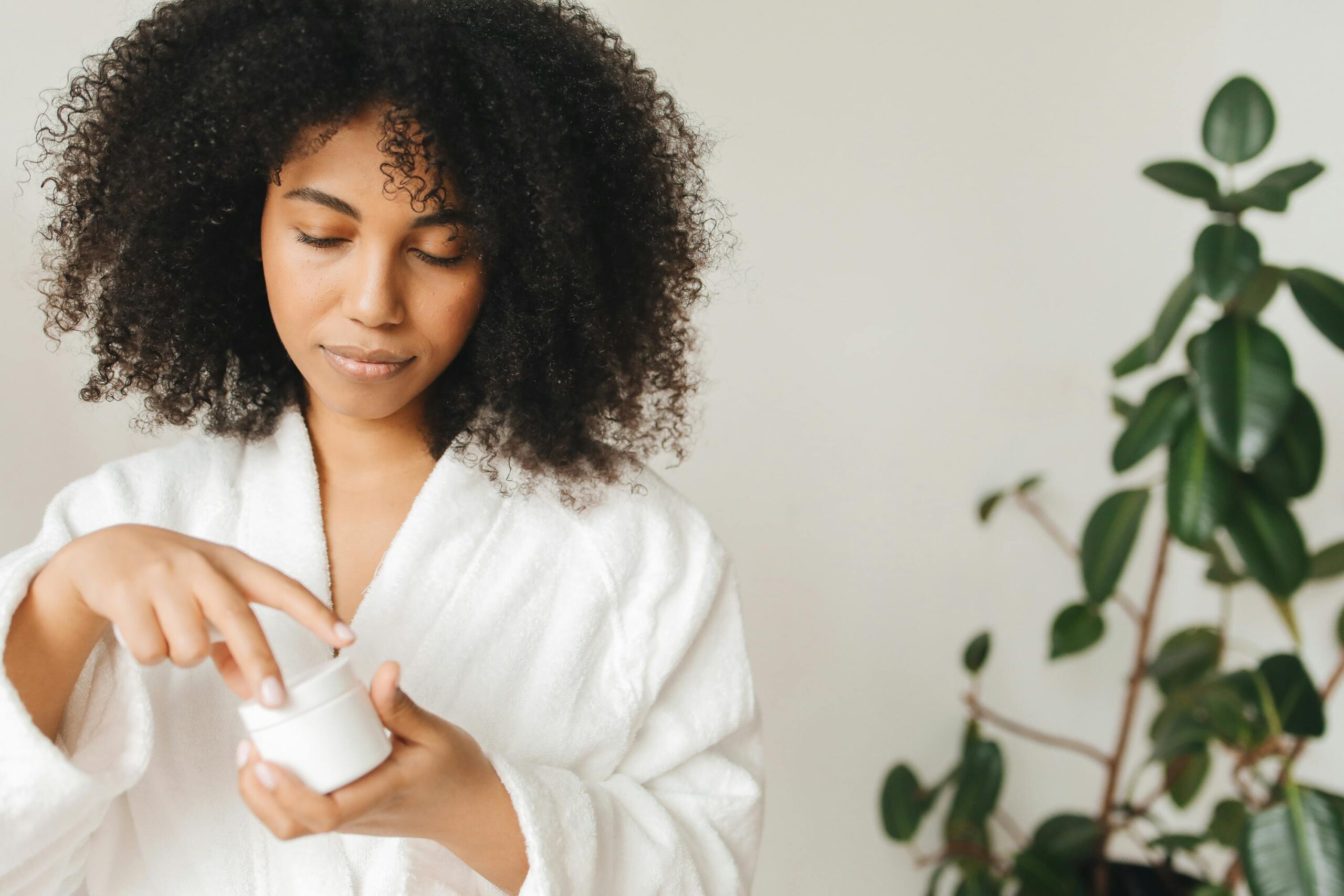 Mulher aplicando creme noturno para skincare, cuidando da pele enquanto dorme.